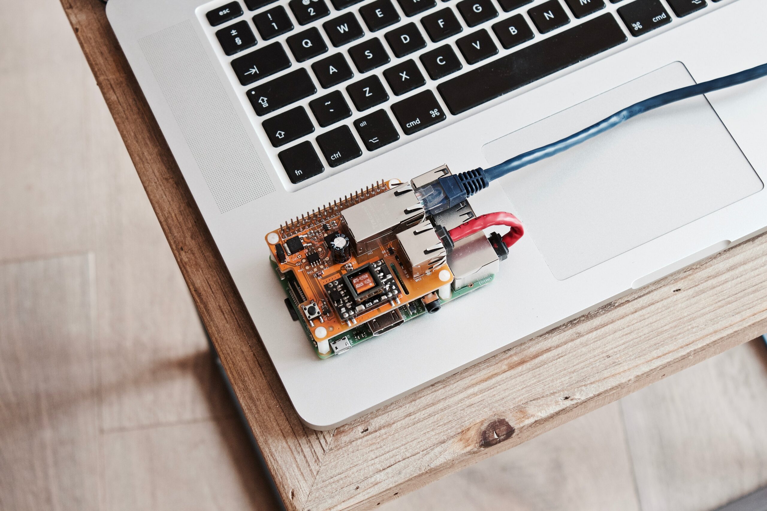 Mini-ordinateur Raspberry Pi posé sur un clavier de laptop, câble ethernet branché