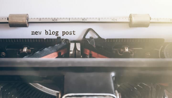 Papier inséré dans une machine à écrire affichant le texte "new blog post"
