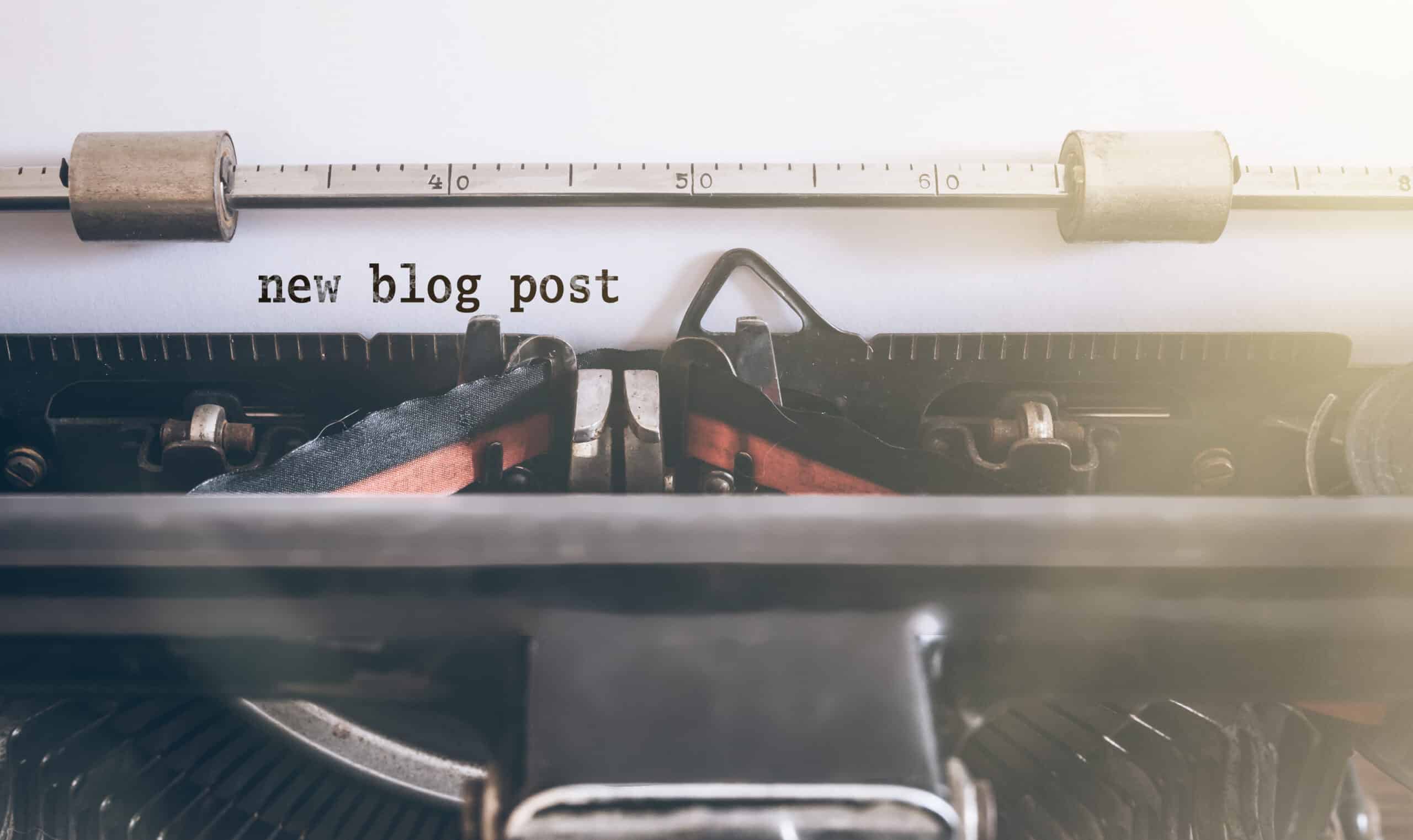 Papier inséré dans une machine à écrire affichant le texte "new blog post"