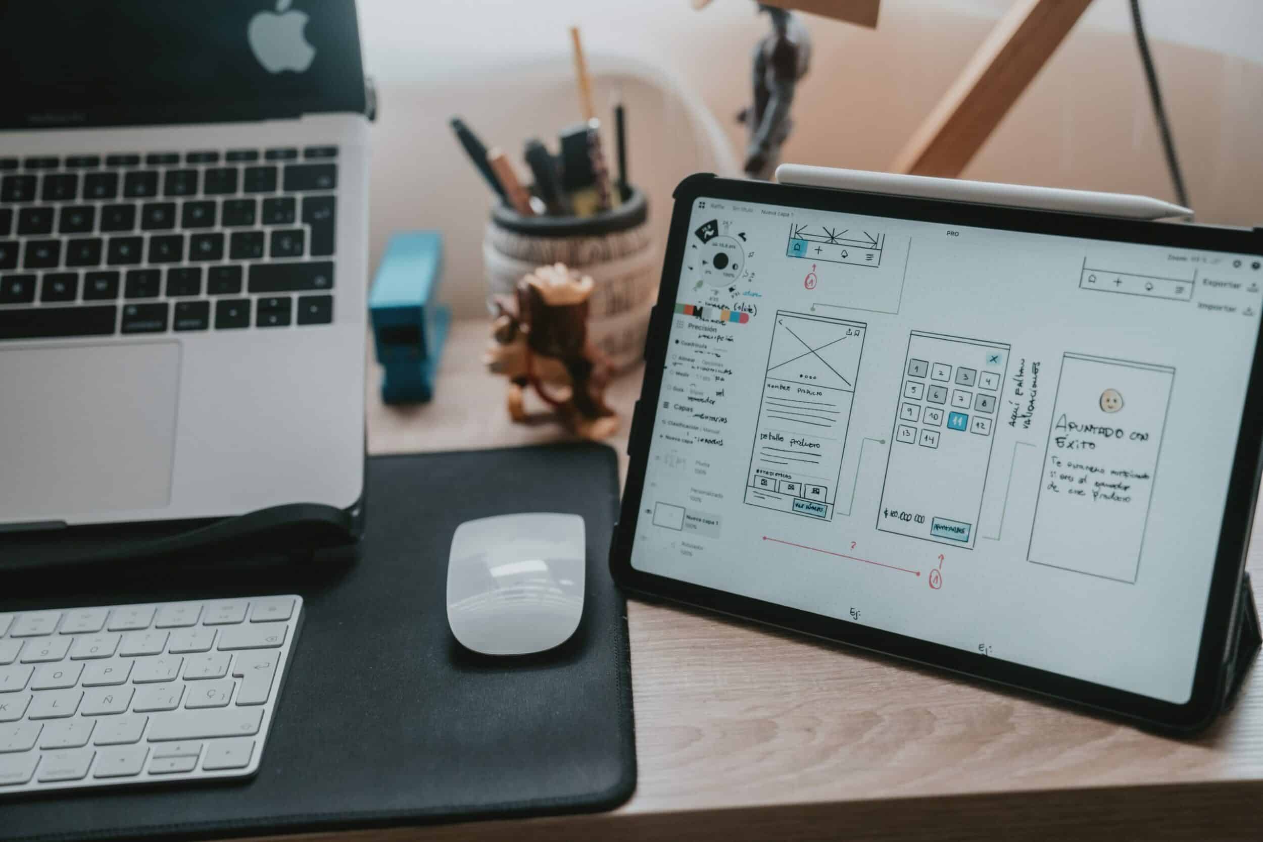 iPad affichant un wireframe d'application à côté d'un clavier et d'une souris
