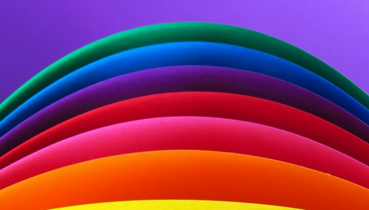 Feuilles de papier colorées courbées en arcs superposés façon arc-en-ciel