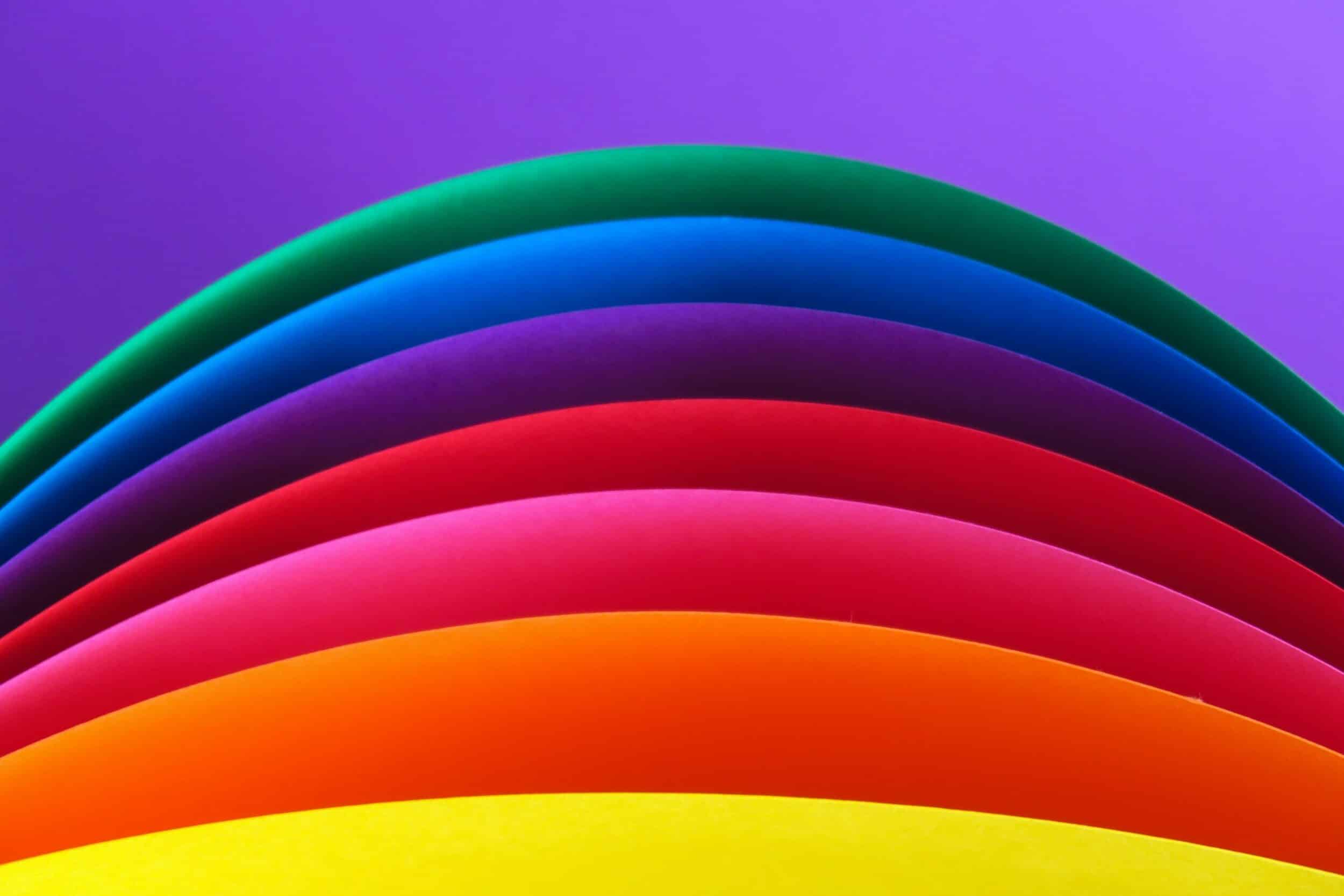Feuilles de papier colorées courbées en arcs superposés façon arc-en-ciel