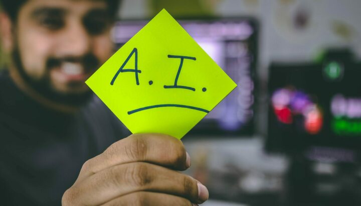 Homme souriant tenant un post-it jaune "A.I." avec bouche triste dessinée
