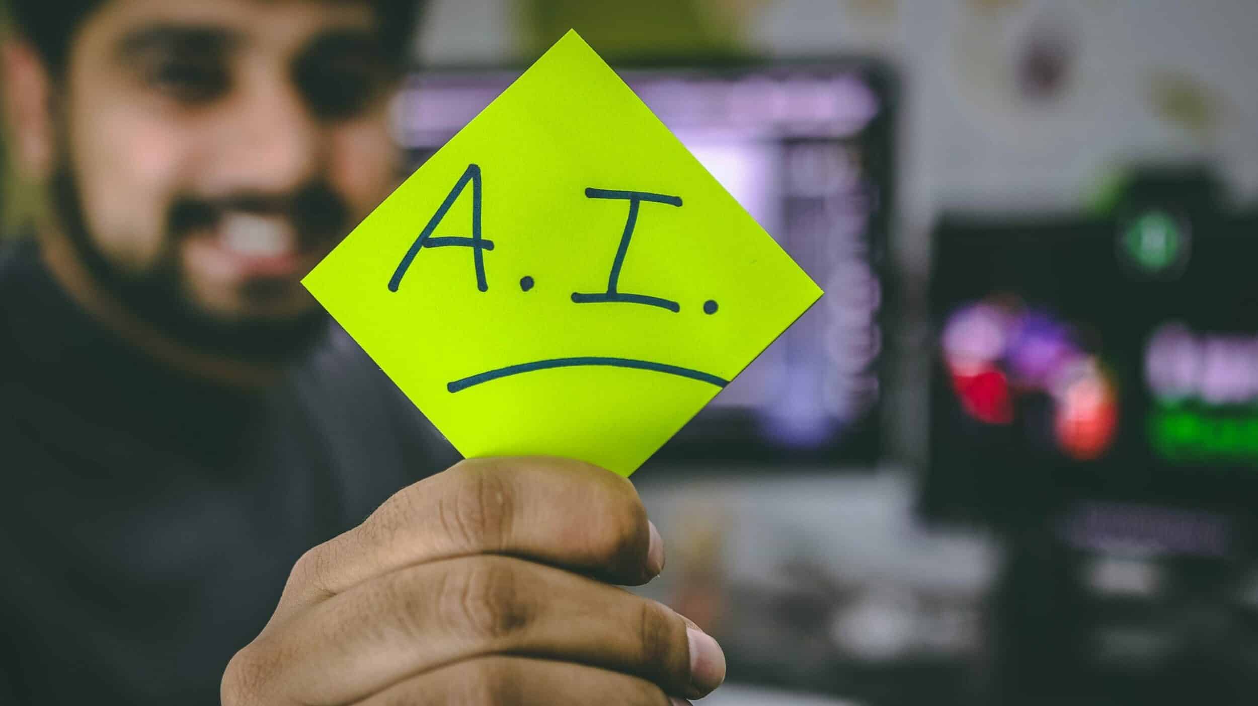 Homme souriant tenant un post-it jaune "A.I." avec bouche triste dessinée