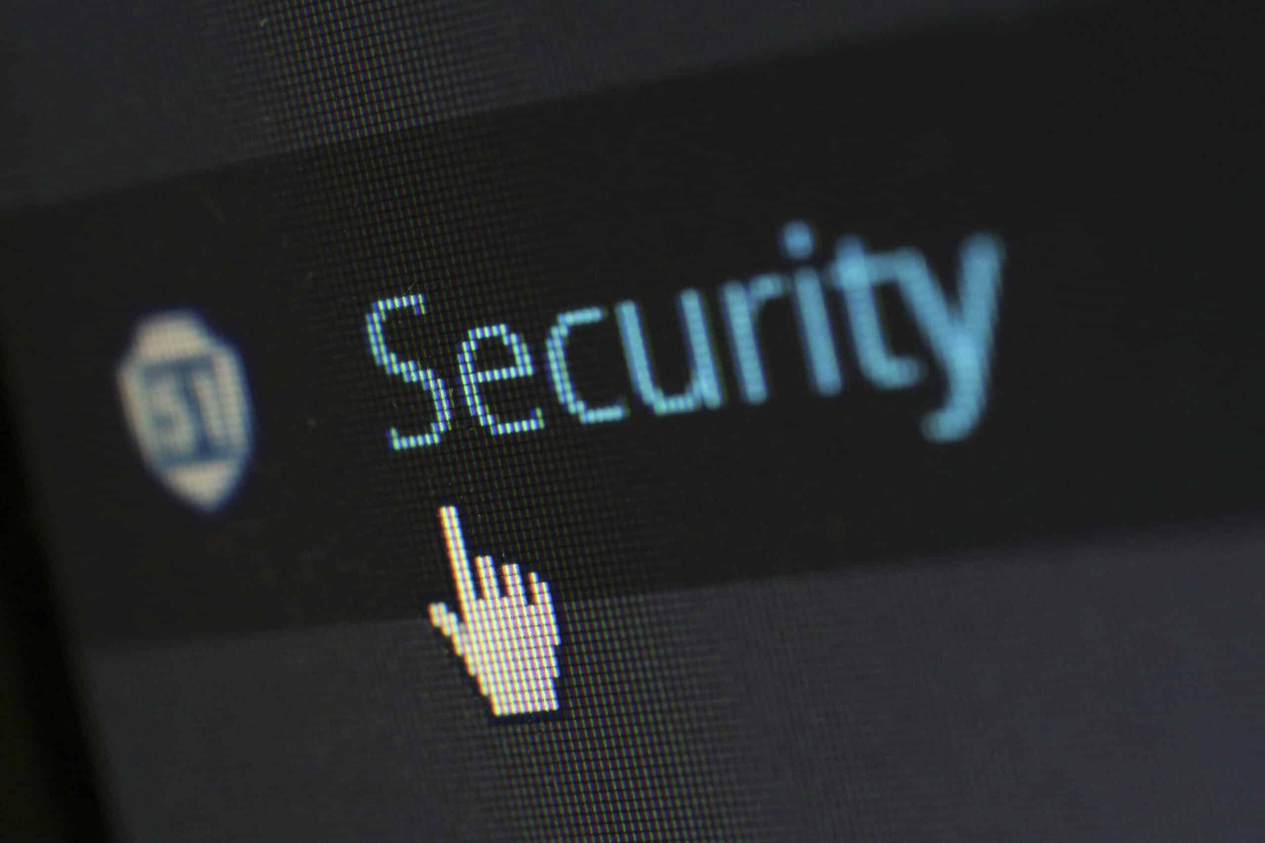 Curseur pointant sur le mot "Security" affiché en gros caractères bleus sur un écran pixelisé