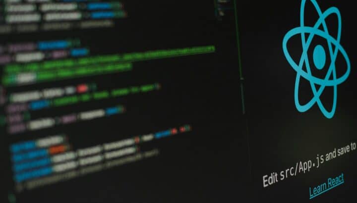 Écran sombre affichant du code et le logo React avec le message "Edit src/App.js and save to reload"