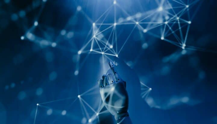 Main robotique touchant un réseau de points lumineux connectés, fond bleu