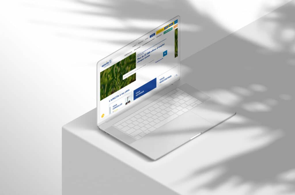 Ordinateur portable affichant la page d'accueil du site Apecita avec champ agricole en arrière-plan