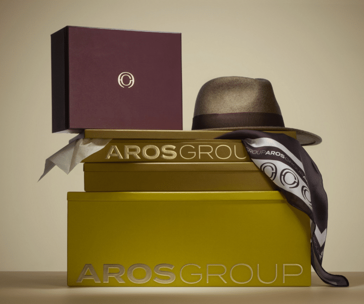 Coffrets de packaging de luxe aux couleurs bordeaux et doré gravés "AROS Group", accompagnés d'un chapeau en feutre et d'un foulard imprimé du logo de la marque